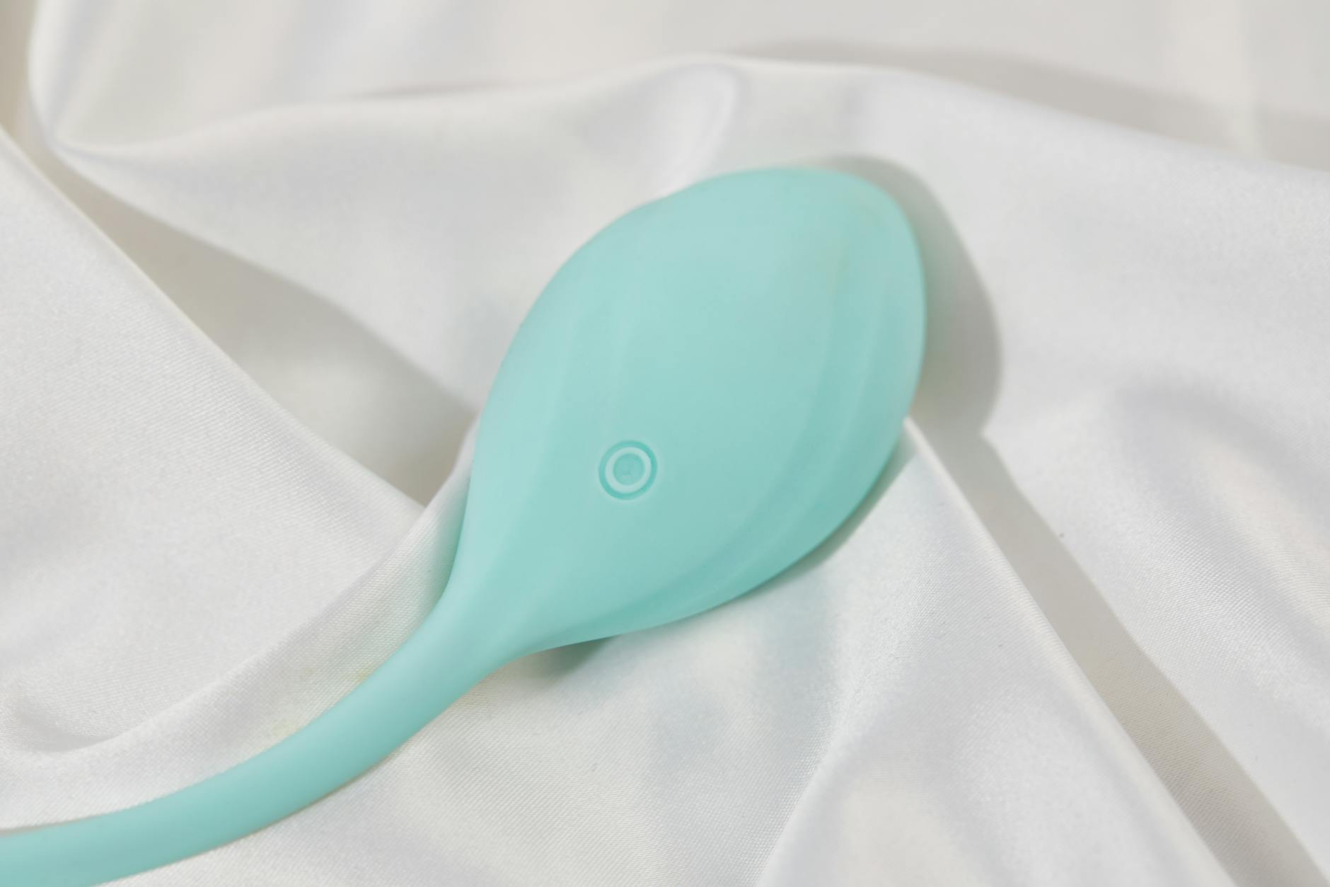 Un vibromasseur citron élégant posé sur une surface de soie blanche lisse