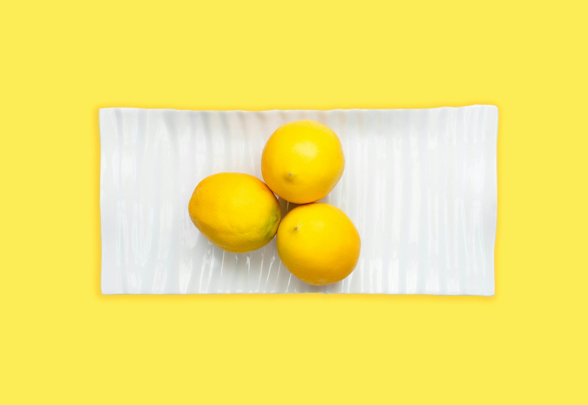Arrangement vibrant de vibromasseurs citron colorés sur une surface jaune vif, mettant en avant la diversité du design et la connexion partagée