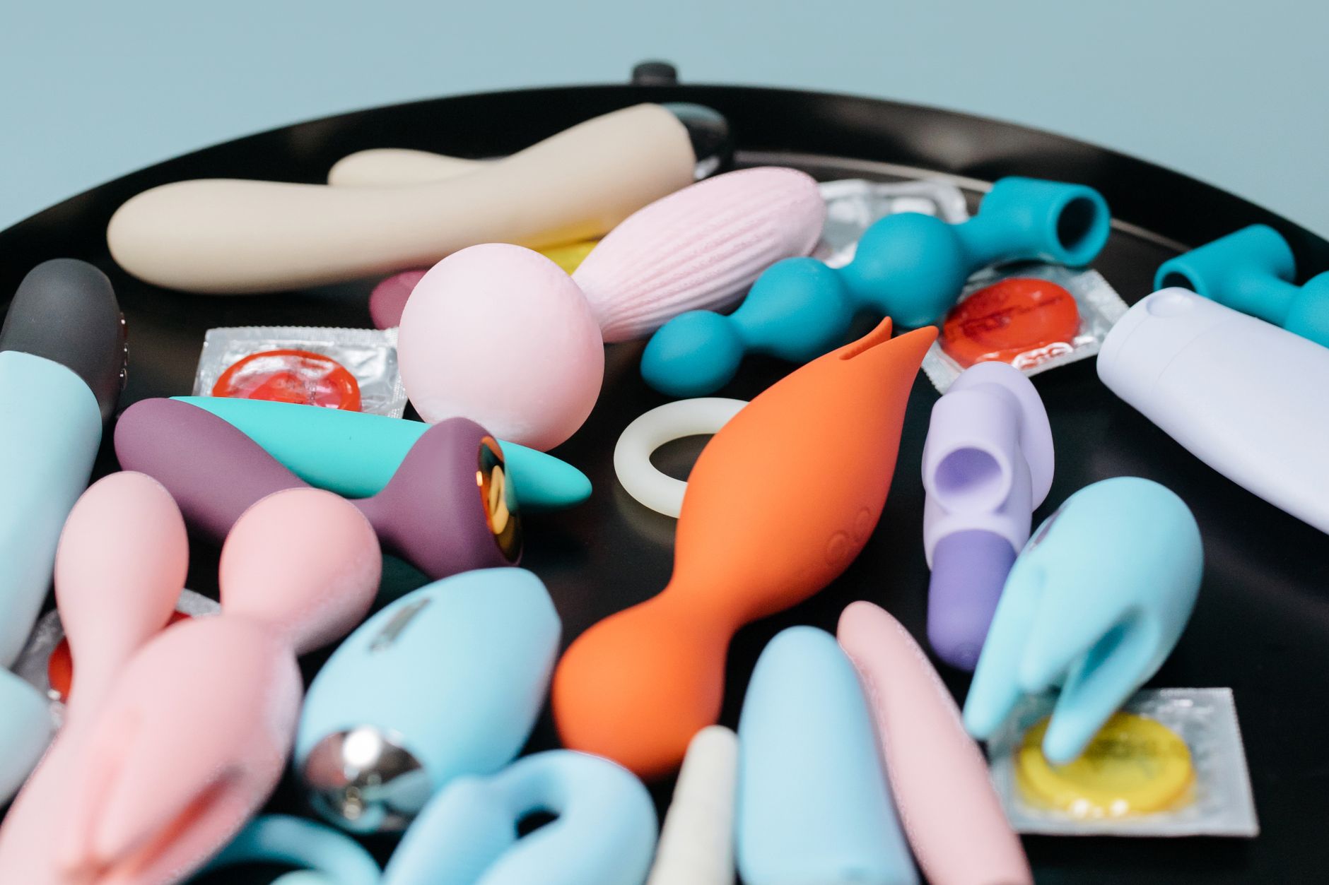 Collection de vibromasseurs adultes de couleurs variées sur un plateau noir