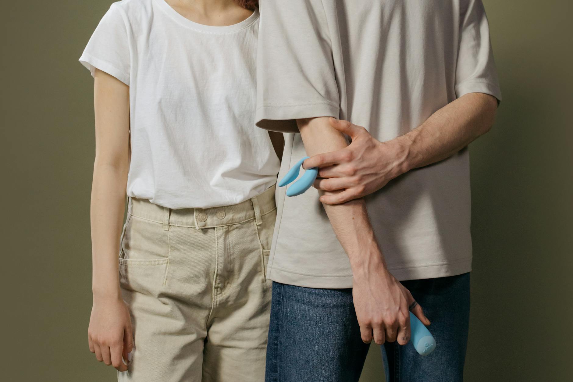Couple partageant un moment intime ensemble, tenant un vibromasseur bleu, symbolisant la modernité et l'intimité partagée