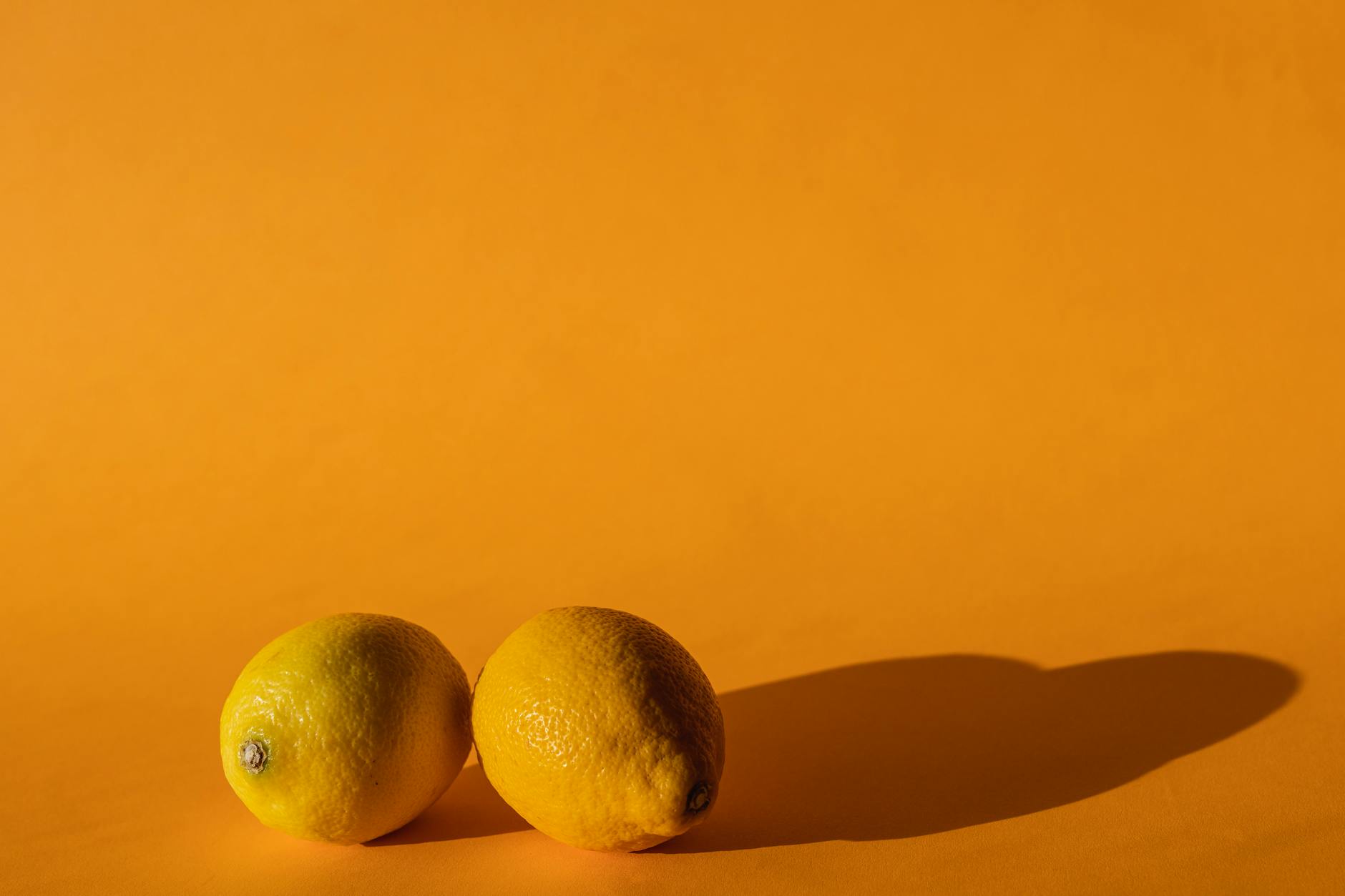 Citrons vibrants disposés avec soin sur un fond pastel, symbolisant la sensibilité et la douceur nécessaires après une hystérectomie.