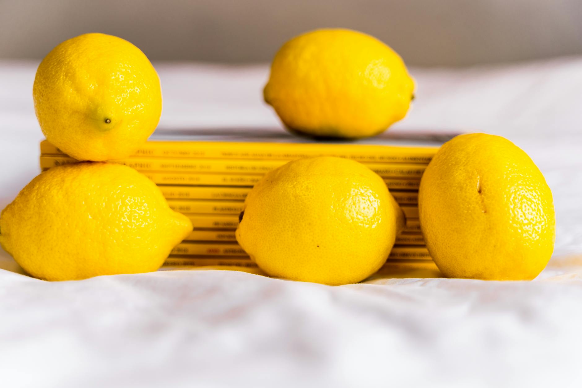 Citrons frais entiers à côté de livres empilés sur une nappe blanche